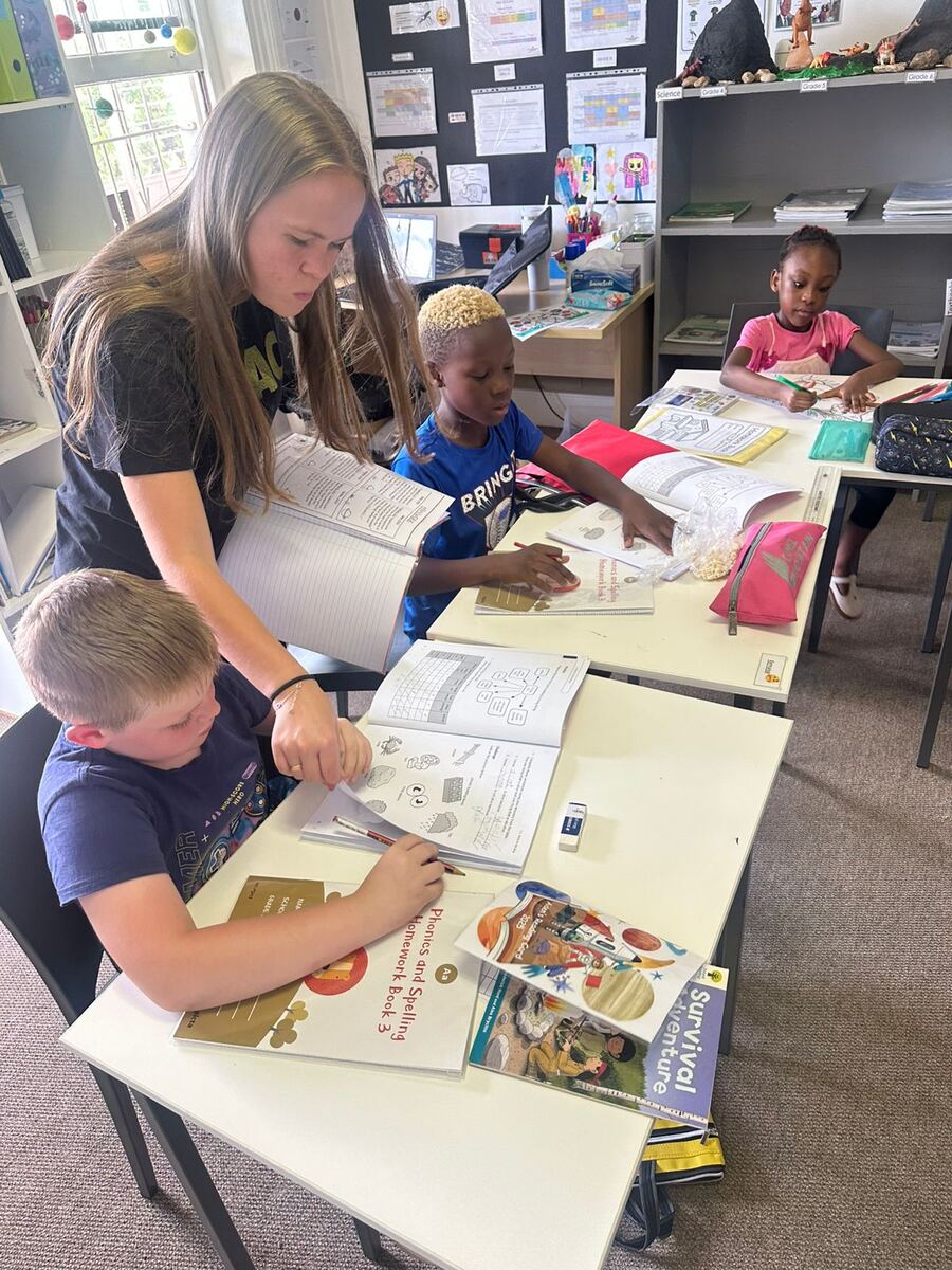 A teacher helping learners one-on-one at a desk